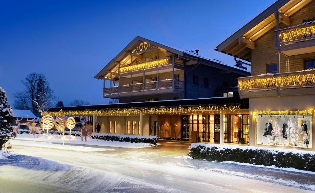 a building covered in christmas lights in the snow at Parkhotel Egerner Höfe in Rottach-Egern