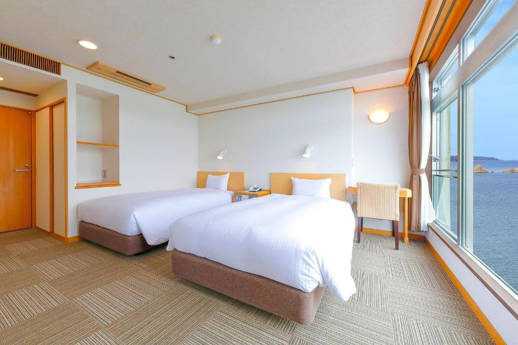 Postel nebo postele na pokoji v ubytování Ooedo Onsen Monogatari Nanki Kushimoto