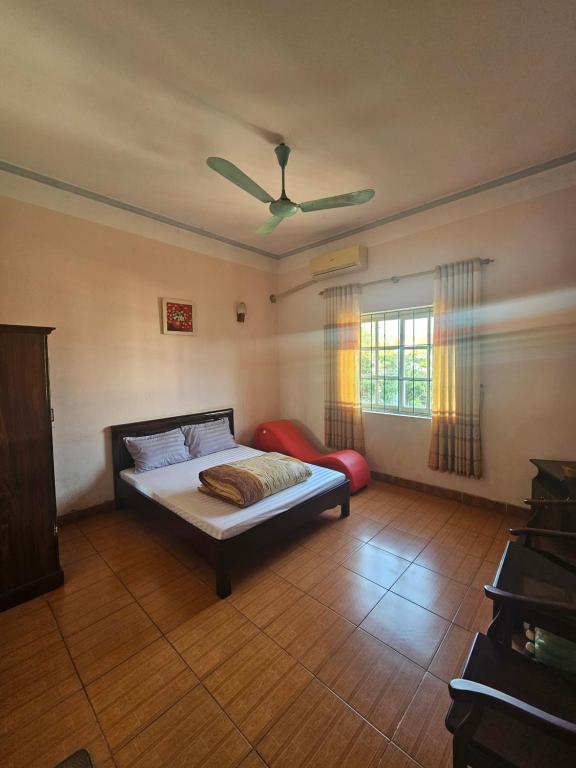 a bedroom with a bed and a ceiling fan at Nhà Nghỉ Thái Thu in Cao Bằng