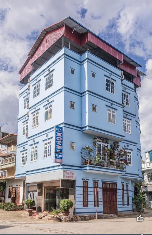 a blue building with windows and plants on it at Nhà Nghỉ Thái Thu in Cao Bằng