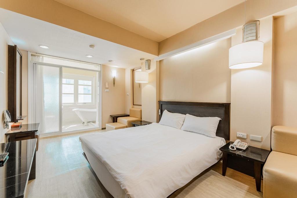 una camera d'albergo con letto e bagno di Guide Hotel Kaohsiung Shinkuchan a Kaohsiung