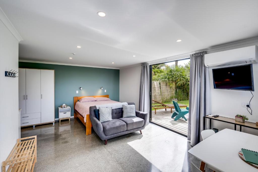 - une chambre avec un lit, un canapé et une chaise dans l'établissement Modern Studio near Clive River, à Clive