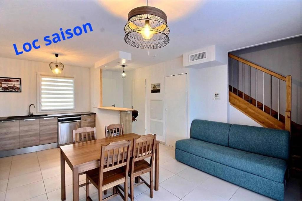 un salon avec un canapé bleu et une table dans l'établissement Azzo, à Sérignan