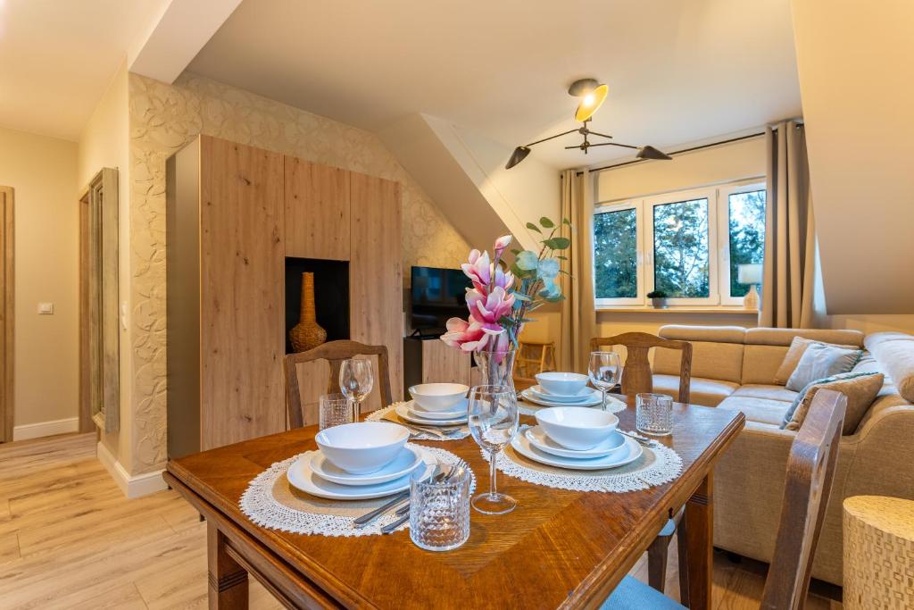 ein Esszimmer und ein Wohnzimmer mit einem Holztisch in der Unterkunft Willa Pod Reglami 14 Apart Invest in Szklarska Poręba