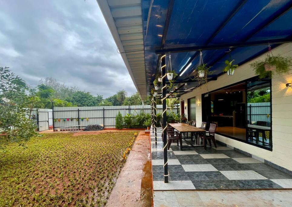 a patio with a table and chairs on a house at Cloud9 Villa (Yeoor Hills, Thane) - A Luxurious Private Jungle Villa. in Thane