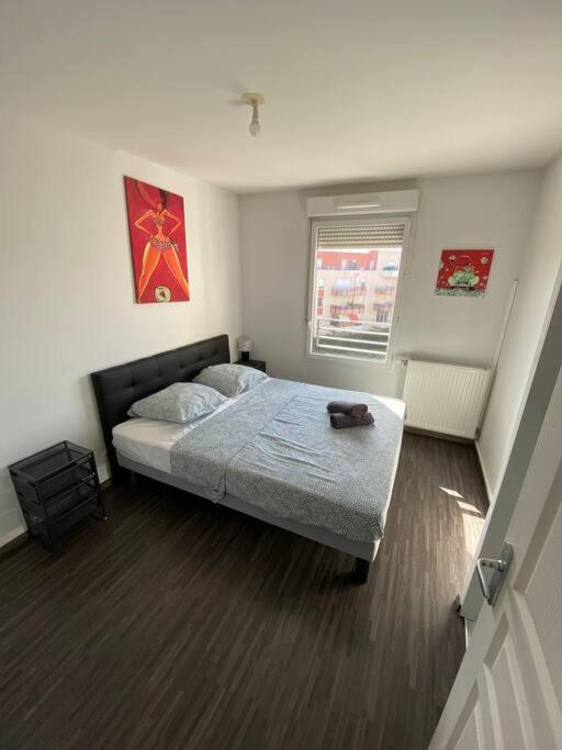 une chambre avec un lit et une fenêtre dans l'établissement Appartement Terrasse + parking, à Clermont-Ferrand