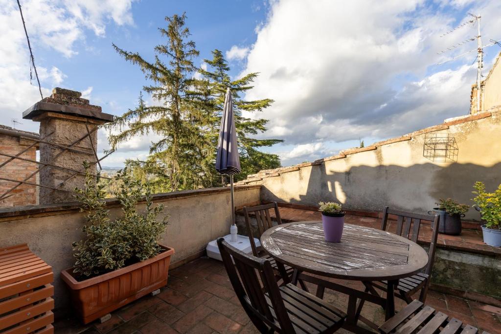 a patio with a table and chairs and an umbrella at Casa Al Cantone in Certaldo