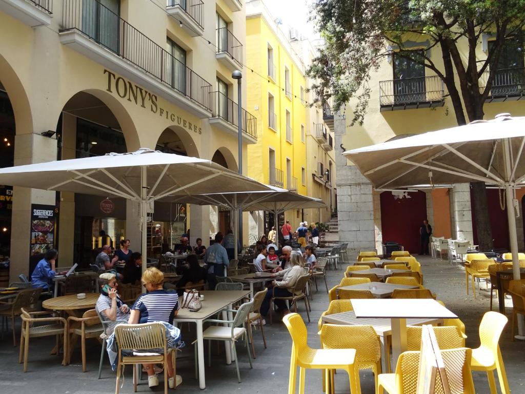 un grupo de personas sentadas en mesas en un restaurante al aire libre en Center Plaza Figueres, en Figueres
