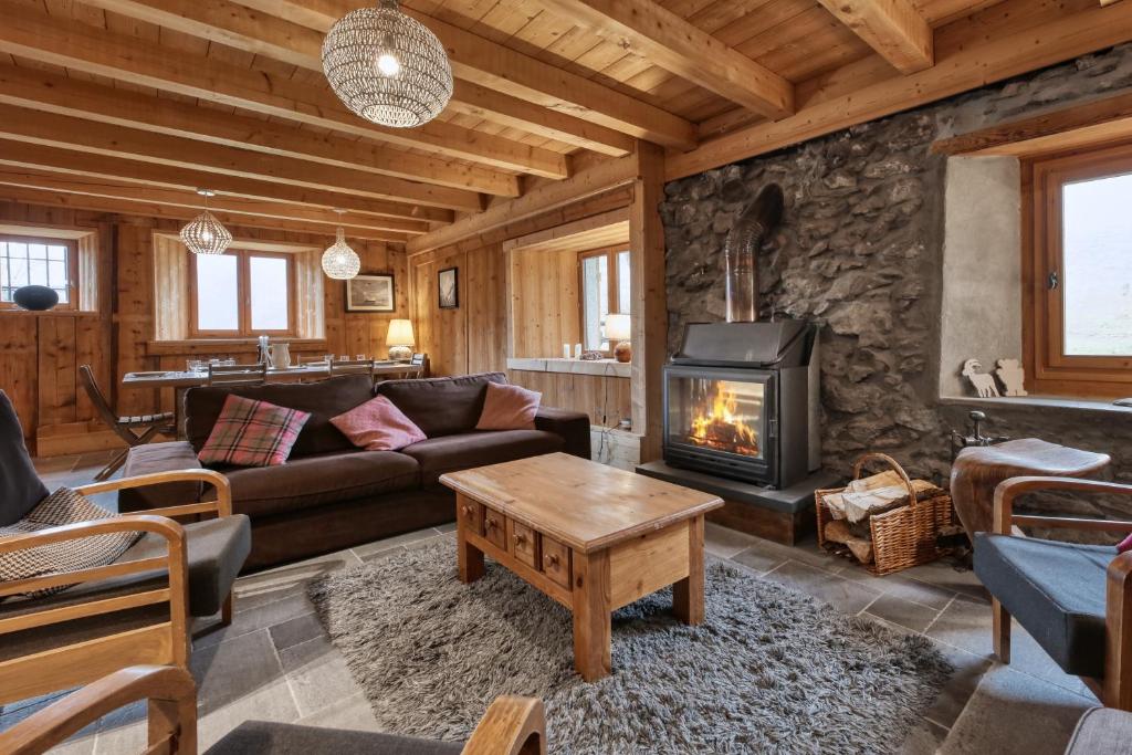 een woonkamer met een bank en een open haard bij La ferme des ours in Saint-Gervais-les-Bains