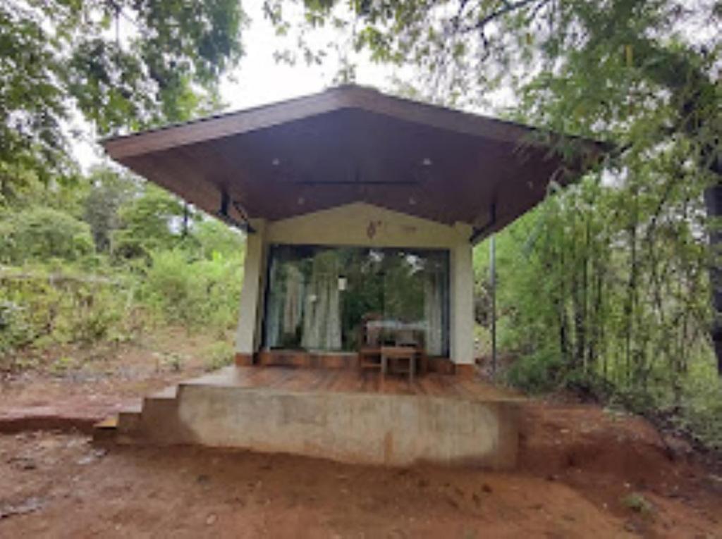 ein kleines Haus mit einem lila Dach im Wald in der Unterkunft Vanoshi Forest Homestay,Kudase in Maneri