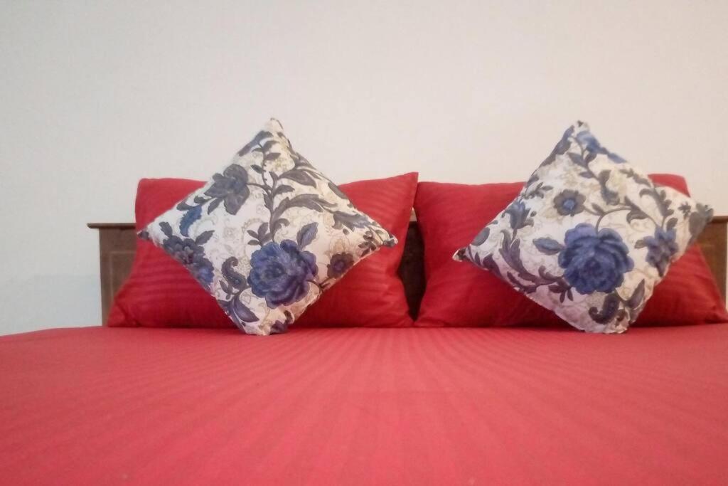 a red bed with two pillows on top of it at Full Large room in Colombo