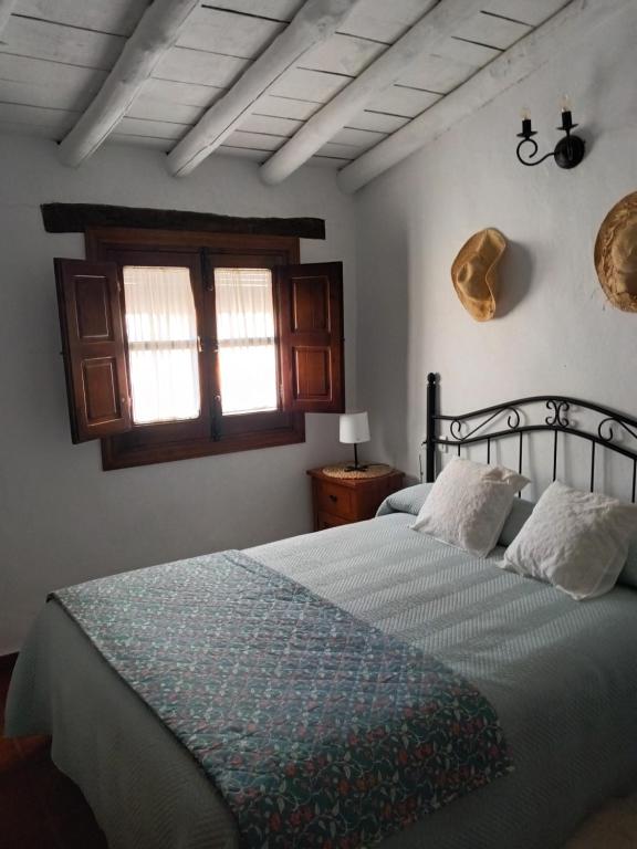 1 dormitorio con 1 cama con manta azul y ventana en Casa Harillo-Charming 1 bedroom in Genal mountains, en Genalguacil