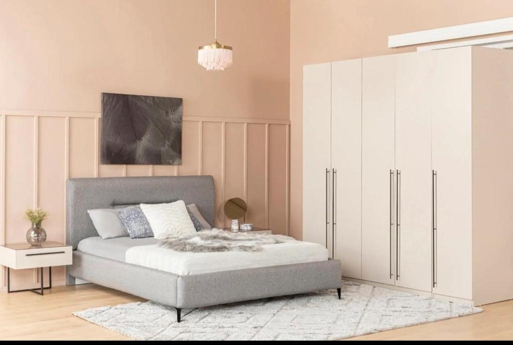 ein Schlafzimmer mit einem Bett und einem großen weißen Schrank in der Unterkunft Necdet apartman in Pasakoy