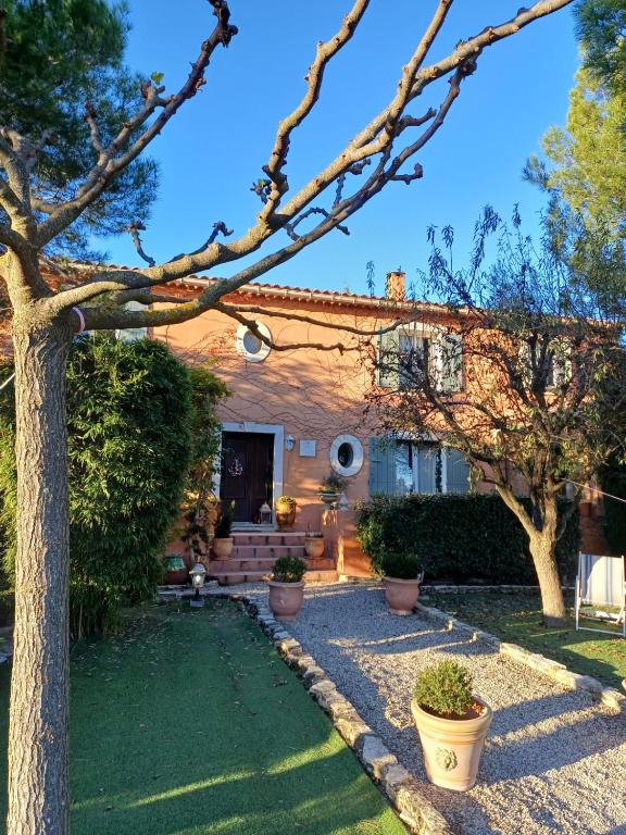une maison avec un arbre dans la cour dans l'établissement Chambre d hôte Lavande 