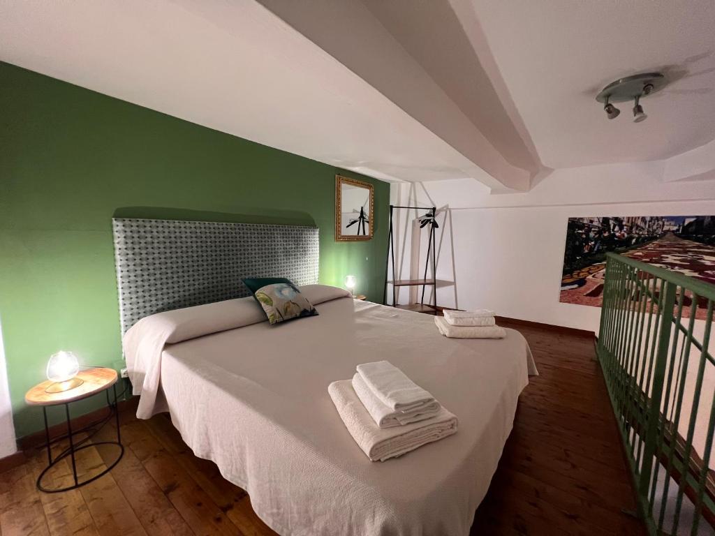 a bedroom with a white bed with green walls at Zigana- Raffinato ed elegante appartamento nel cuore della città! in Palermo