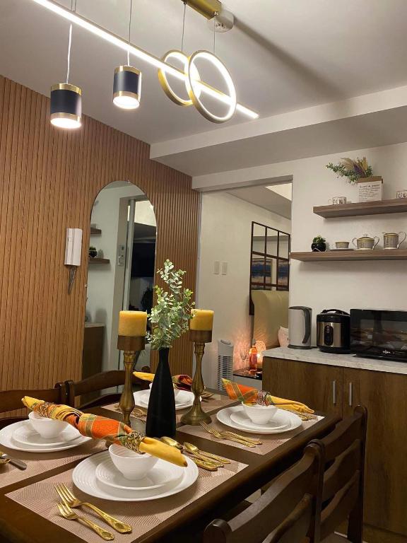 una mesa de comedor con platos y utensilios. en Azure Air bnb, en Maimpis