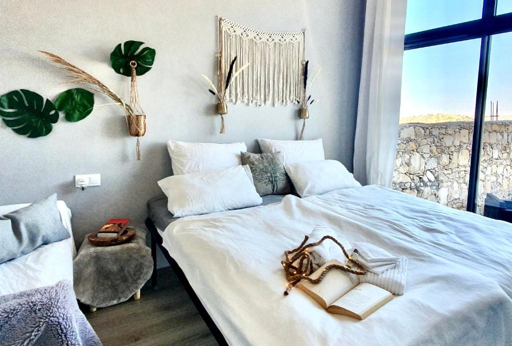 a bedroom with a bed with books and a window at Villa Tafoukt Taghazout in Taghazout