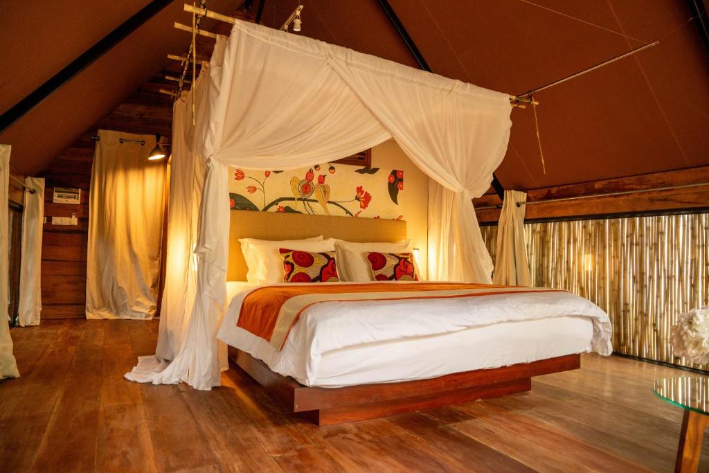 a bedroom with a bed with a canopy at Treellion Jungloo in Phnom Penh