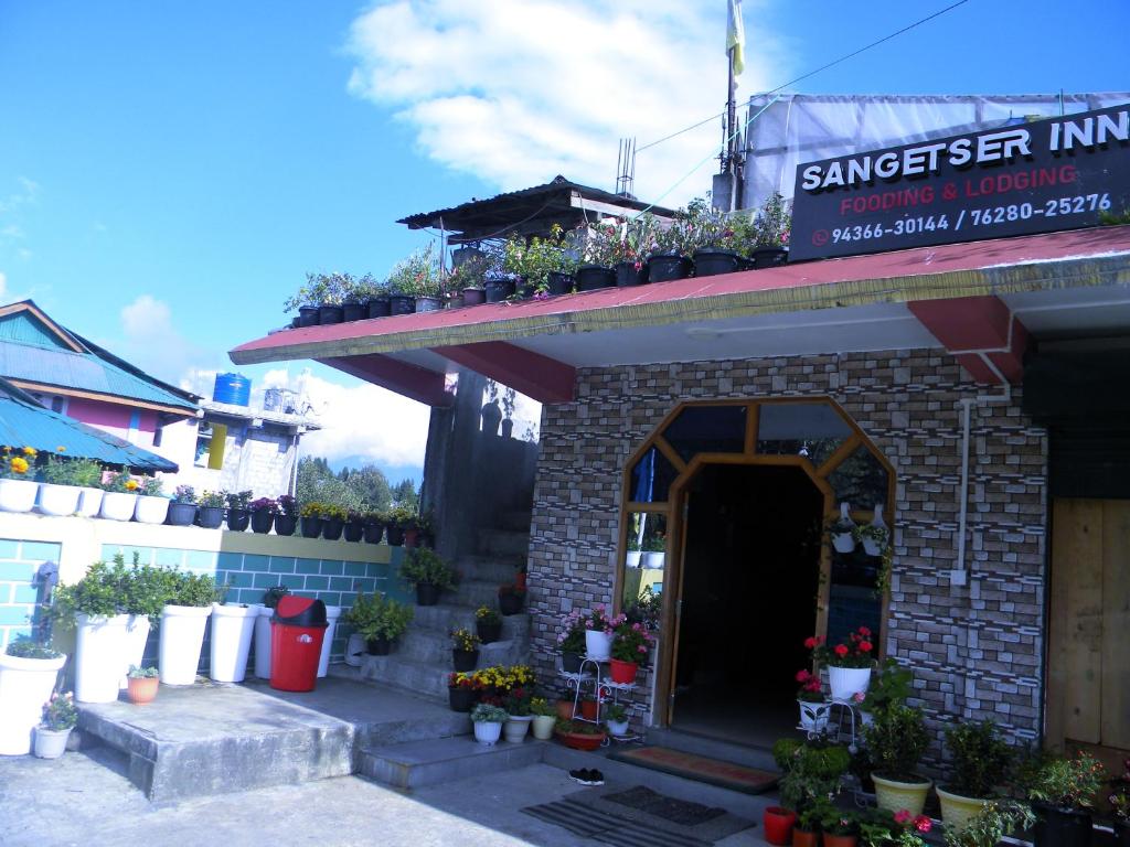 a building with potted plants on top of it at Shungatser inn in Tawang