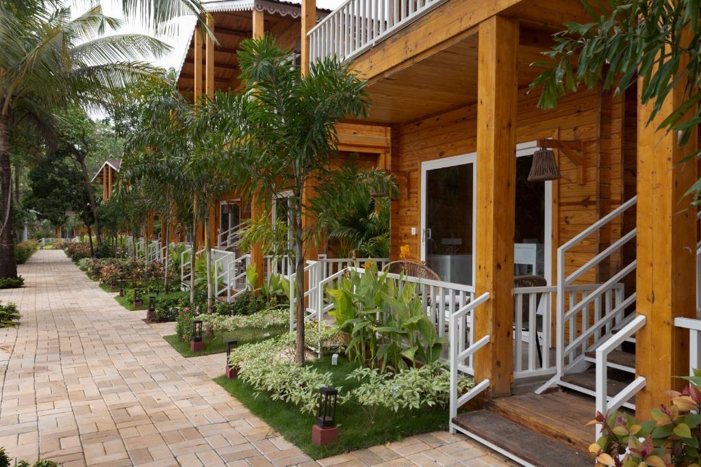 a house with trees and plants in front of it at Aralea Beach Resort By Stone Wood Premier in Morjim