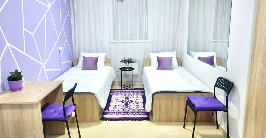 pokój z 2 łóżkami i 2 krzesłami w obiekcie Like Home Hostel na Timiryazeva w mieście Ałma-Ata