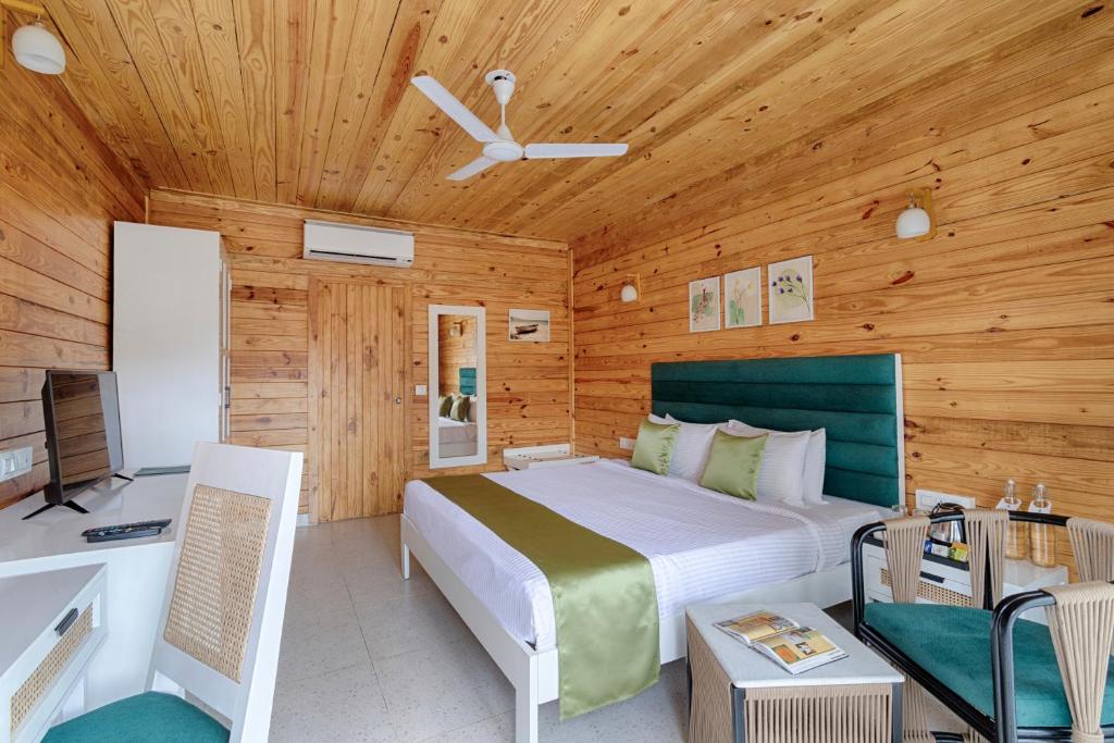 a bedroom with a bed and a wooden ceiling at Aralea Beach Resort By Stone Wood Premier in Morjim