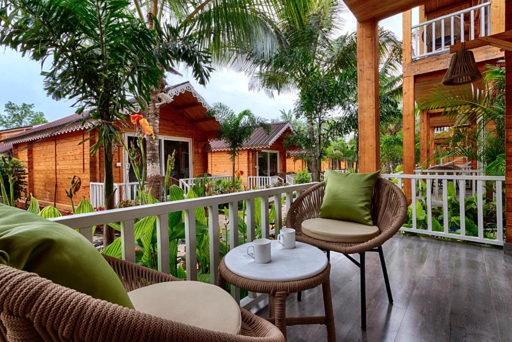 an outdoor patio with chairs and a table at Aralea Beach Resort By Stone Wood Premier in Morjim