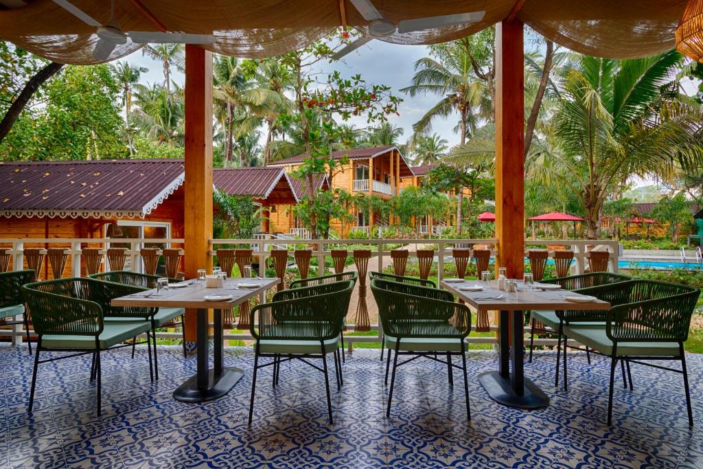a restaurant with tables and chairs and a pool at Aralea Beach Resort By Stone Wood Premier in Morjim