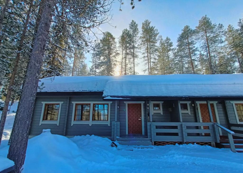 a house covered in snow in the woods at Nelisyöte A in Syöte
