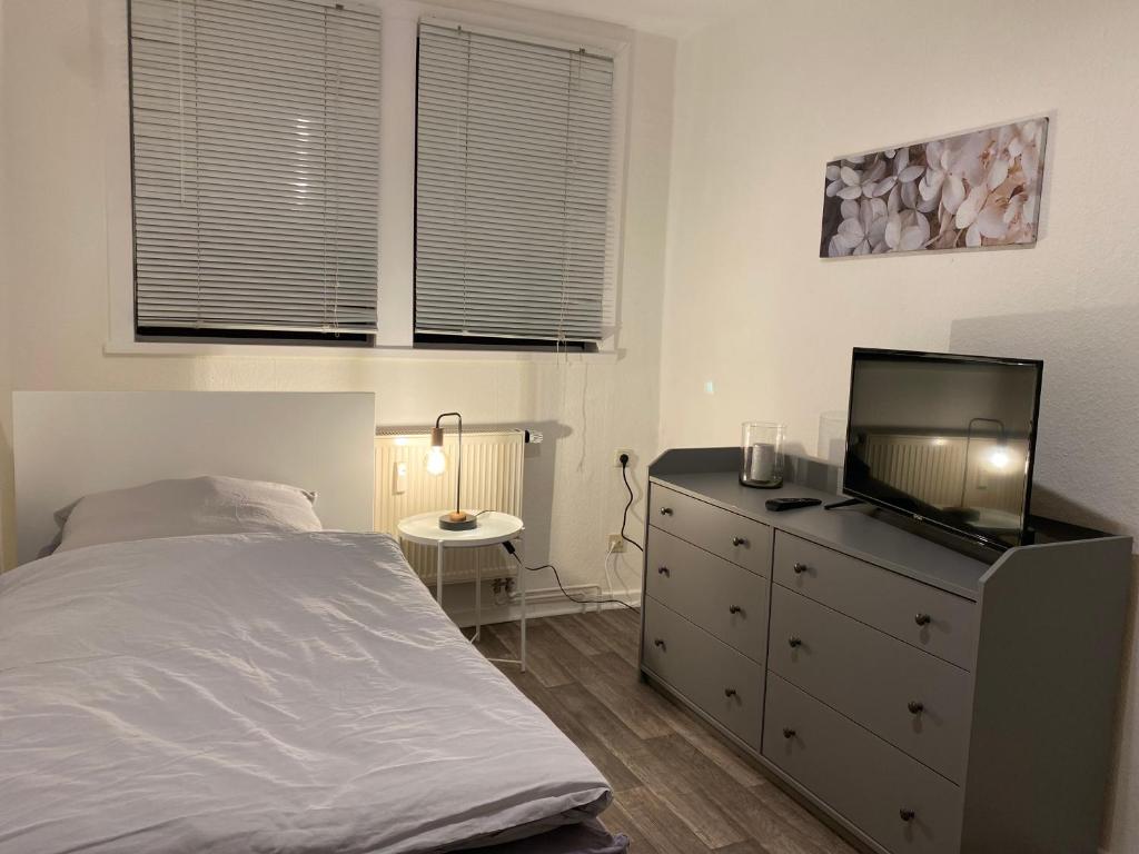 a bedroom with a bed and a tv on a dresser at Balance Apartments by M&A - Train station in Witzenhausen