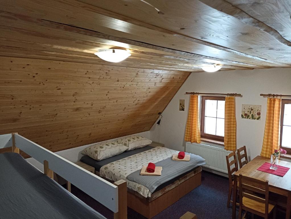 Chata Dáša في كورينوف: غرفة نوم بسريرين وطاولة في غرفة