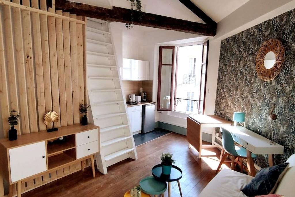 ein Wohnzimmer mit einem Schreibtisch und einer Küche in der Unterkunft L'Alisier Du Centre Dijon in Dijon