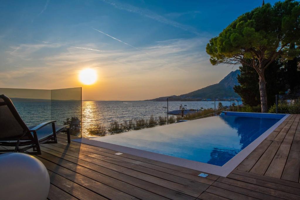 einen Pool auf einer Terrasse mit Blick auf das Wasser in der Unterkunft Villa Brzet - Luxury Boutique Apartments in Omiš