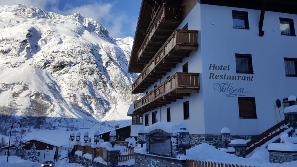 un hotel con una montaña cubierta de nieve en el fondo en Hotel Valisera, en Galtür