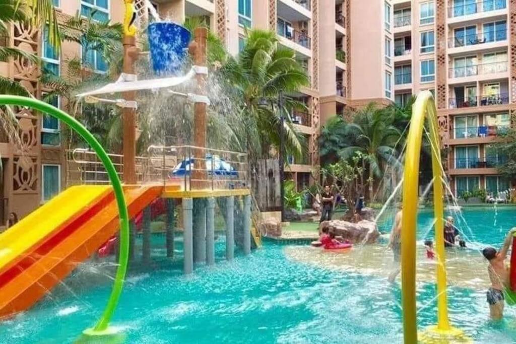 a pool at a resort with a slide in the water at Seaview Atlantis Condo Resort Jomtien Beach Water Park in Jomtien Beach