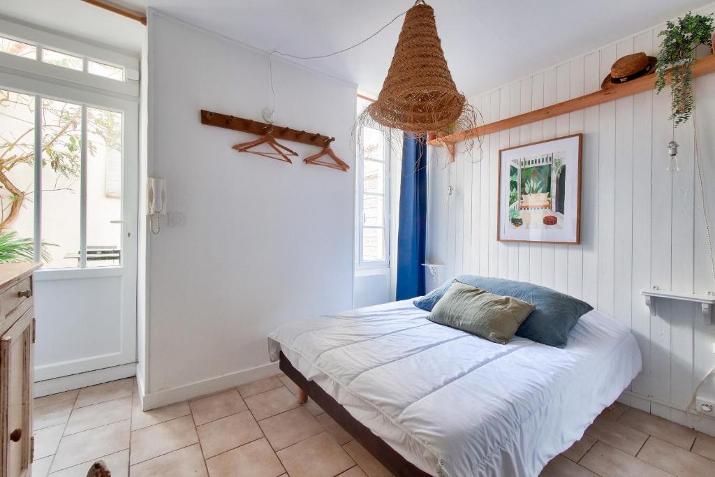 een slaapkamer met een bed en een raam bij La Suite - Port de Saint-Martin-de-Re in Saint-Martin-de-Ré
