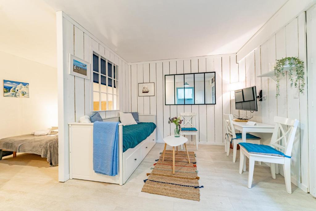 une chambre avec un lit, un bureau et une table dans l'établissement Le Relax - Appt avec terrasse à 5mn de la plage, à Arcachon
