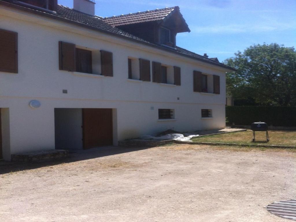 een groot wit huis met een grote garage bij Gite Le Plessis in Chailles