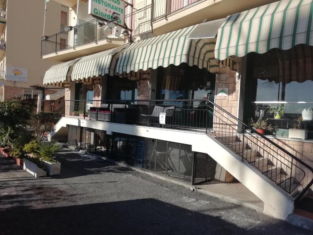 a building with a staircase in front of a store at HOTEL GIORDANA in Loano