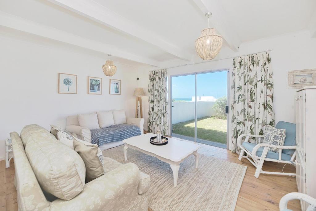 una sala de estar con un sofá y una mesa en Chez Nous In Arniston, en Arniston