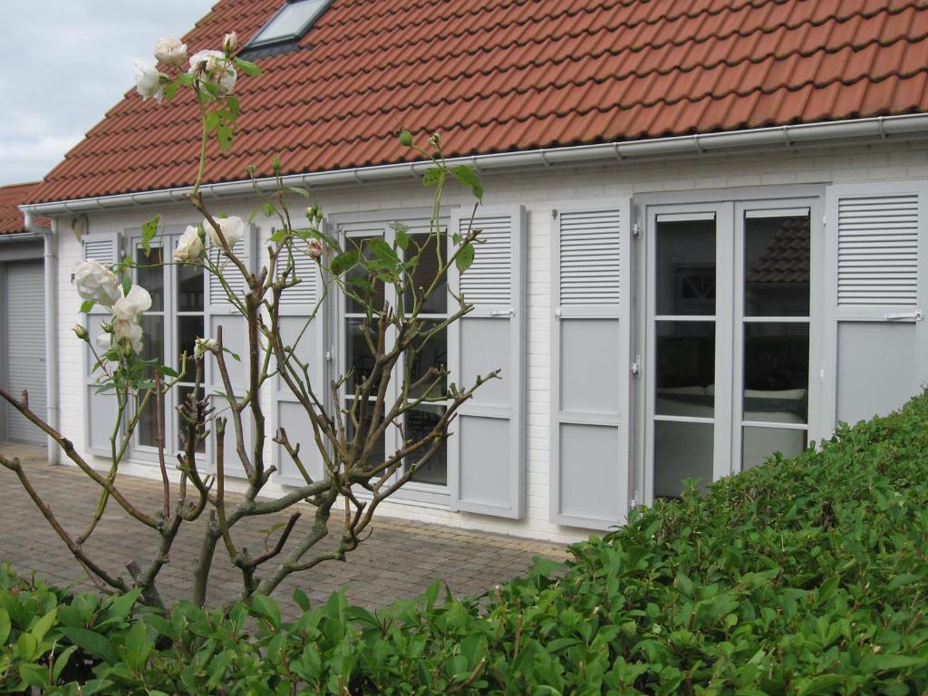 a house with white doors and a red roof at Floris'Home in De Haan