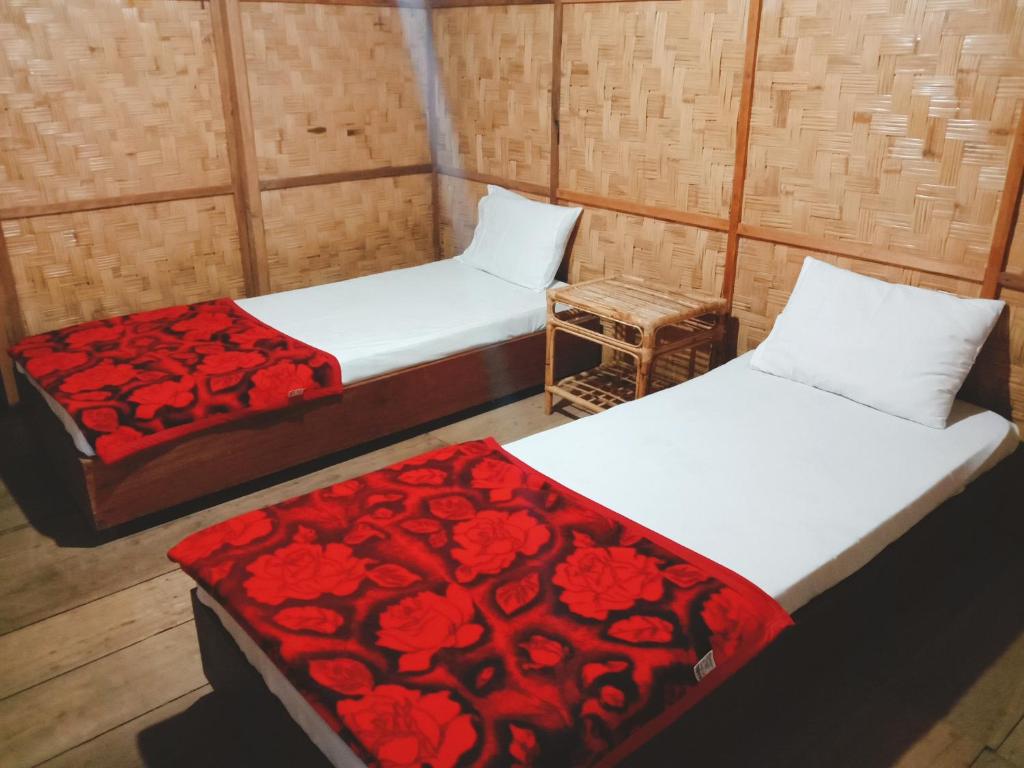 a room with two beds and a chair at Angel's Homestay Batutumonga in Rantepao