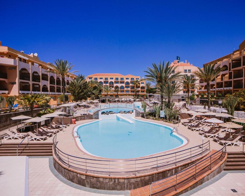 a pool at a resort with lounge chairs and a resort at Mirador Maspalomas by Dunas in Maspalomas