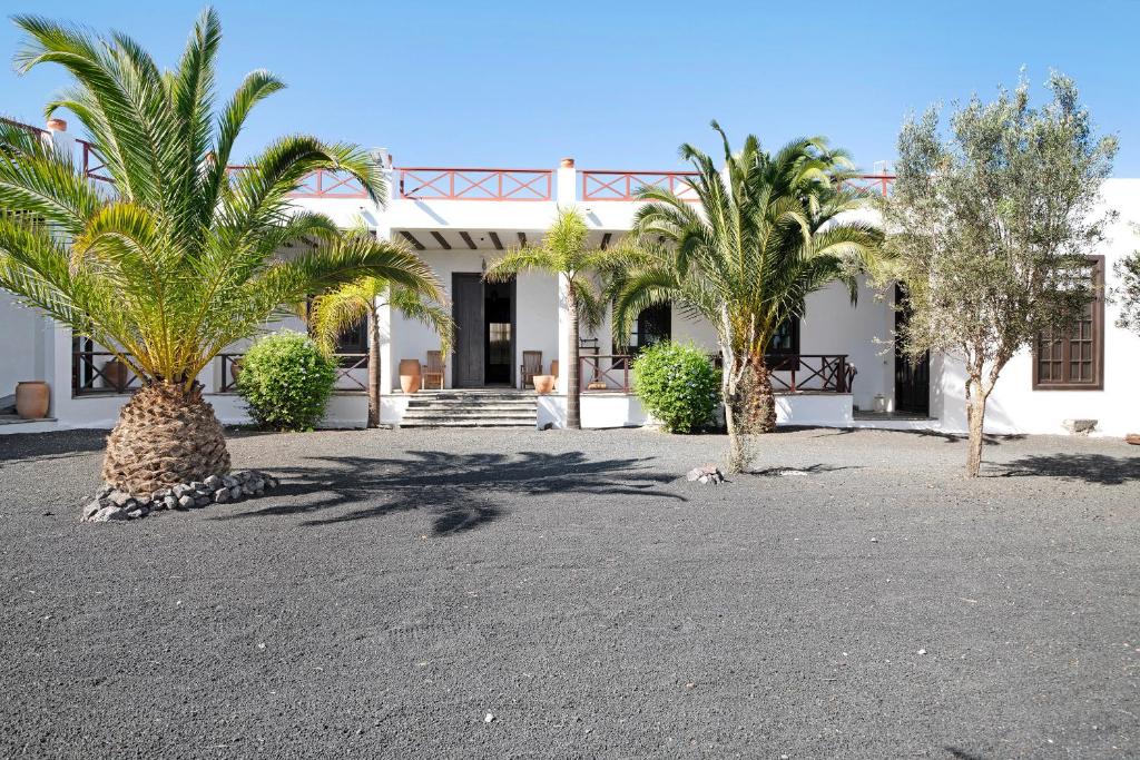een wit gebouw met palmbomen ervoor bij Finca Emblemática - Nº3 Liria in La Vegueta