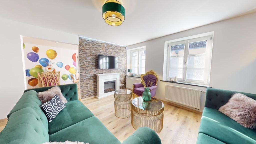 uma sala de estar com um sofá verde e uma lareira em Hufschmieds Bleibe em Passau