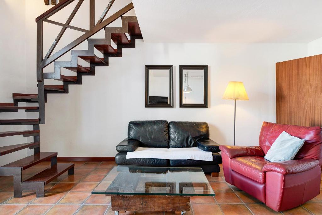 een woonkamer met een leren bank en een trap bij Finca Emblemática - Nº5 Tinache in La Vegueta