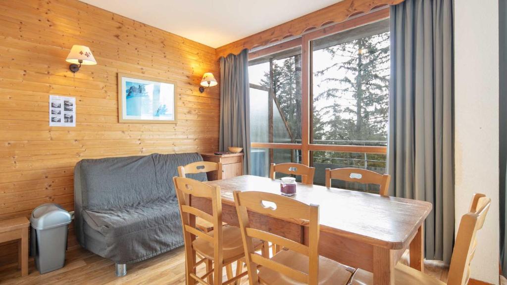 a dining room with a table and a couch at V du Bachat Silenes B11 Appt belle vue 4 6 pers in Chamrousse