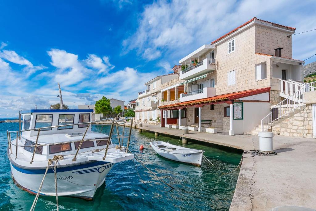 a boat docked at a dock next to a building at Apartments Bety in Dugi Rat