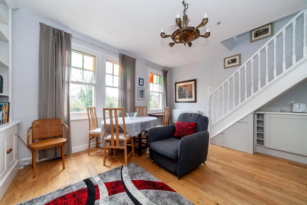 ein Wohnzimmer mit einem Tisch und Stühlen in der Unterkunft Stylish 3 BDR apartment wfree parking and garden in Kingston upon Thames