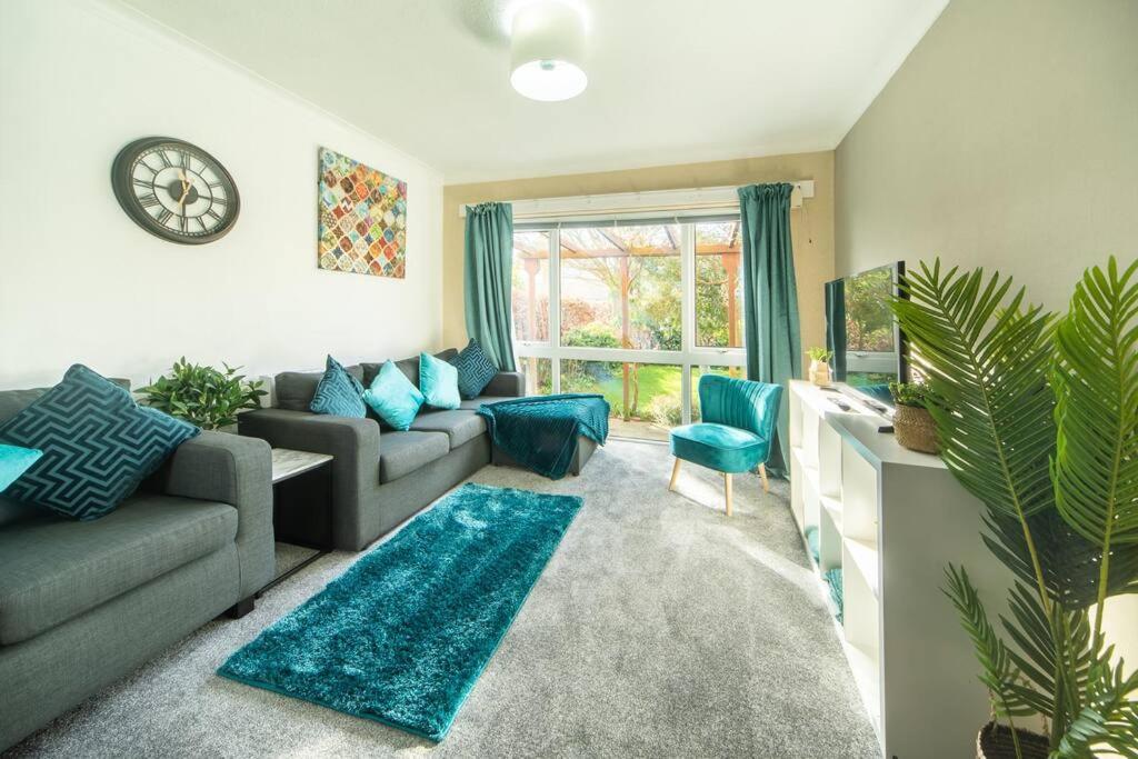 un soggiorno con divano grigio e cuscini blu di Charming 4-Bedroom House-York a Stockton on the forest